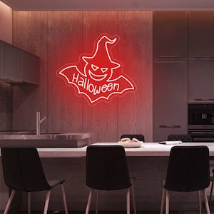 May include: A red neon Halloween sign featuring a witch's hat and a smiling face, with the word "Halloween" underneath. The sign is mounted on a wooden wall in a kitchen setting.