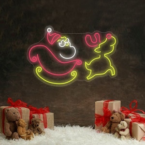 May include: A neon sign showing Santa Claus in his sleigh with a reindeer, in pink, white, and yellow. The sign is set against a dark background with wrapped gifts and teddy bears.