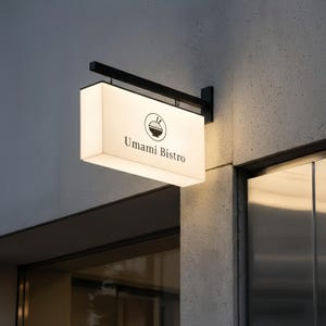 May include: Illuminated rectangular sign for Umami Bistro, mounted on a building exterior. The sign is white with black text and a bowl graphic. The sign is suspended by a black metal bracket.