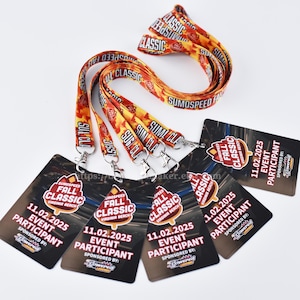 May include: Event lanyards and participant cards. The lanyards are yellow and orange with the text "SUMOSPEED FALL CLASSIC". The participant cards are black with event details and the date 11.02.2025.