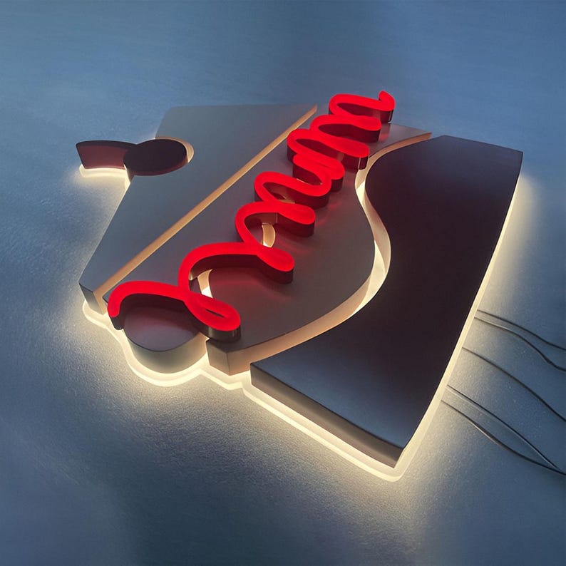 May include: A white and black sign with a red neon "Mama" sign. The sign is lit from behind, creating a warm glow.