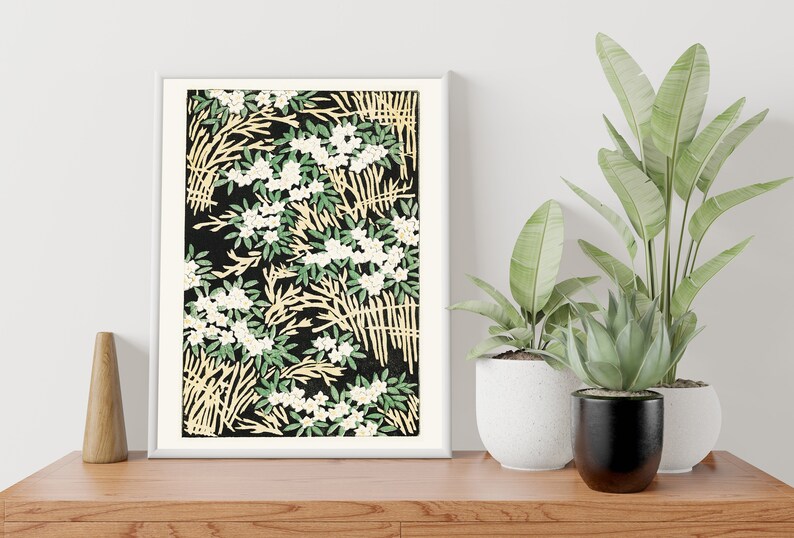 May include: A framed print with a black background and a repeating pattern of white flowers, green leaves, and yellow branches.