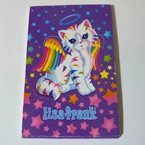 May include: A purple background with a white cat with rainbow wings and a halo. The cat has black stripes and a pink nose. The background is covered in pink and white stars. The text "Lisa Frank" is printed in white letters on the bottom of the image.