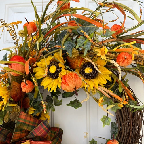 Fall shops front door wreath made with pumpkins, sunflowers, bow and fall greenery