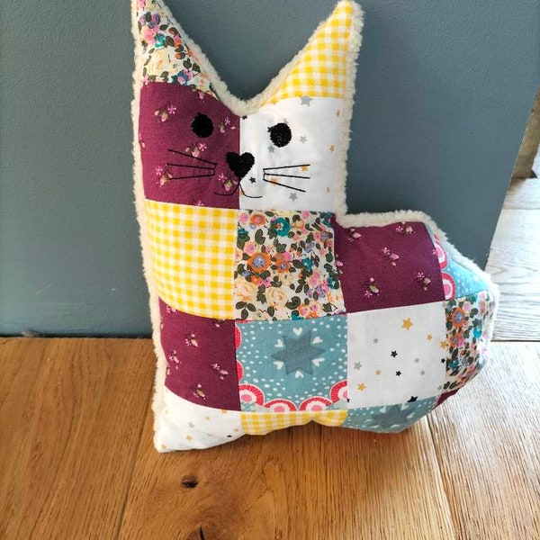 patchachat est un coussin doudou chat en tissu patchwork et  polaire au dos dans les tons de bleu jaune et violet