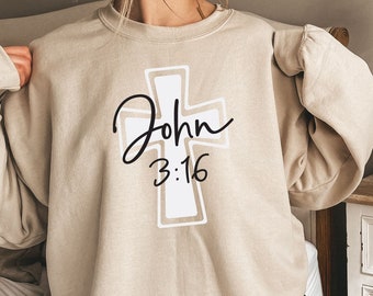 May include: A beige sweatshirt with a white cross and the text "John 3:16" in black.