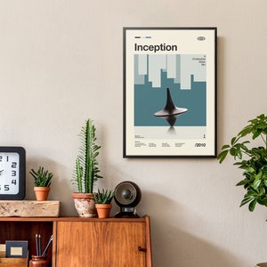 May include: A black framed poster with a minimalist design featuring the title "Inception" in white text. The poster also includes the name "Christopher Nolan Film" and the year "2010". The poster features a spinning top, a key element from the film.