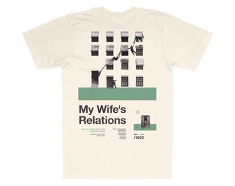 Può includere: Una t-shirt beige con una grafica in bianco e nero di un edificio con persone che scalano dalle finestre. La grafica è una locandina del film "My Wife's Relations" diretto da Edward F. Cline e interpretato da Raymond Hatton e Dorothy Devore. La locandina include anche l'anno 1922.