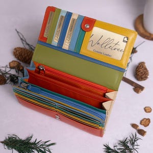 May include: A multi-coloured leather wallet with a yellow flap that says "Walletree Genuine Leather". The wallet is open and shows multiple card slots and a zipped compartment.