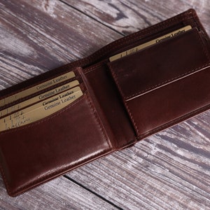 May include: A brown leather wallet with multiple card slots and a flap closure. The wallet has the words "Genuine Leather" printed on the inside.