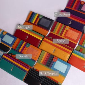 May include: A collection of ten colorful leather wallets with different patterns and names, including Glacier, Midnight, Servile, Black Tropical, Spice, China Rose, Sky, Pacific.