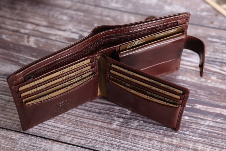 May include: A brown leather wallet with multiple card slots and a zippered compartment. The wallet is open and the interior is visible, showing the card slots and the zippered compartment. The wallet is made of genuine leather and has a logo on the front.