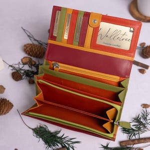 May include: A multi-colored leather wallet with a yellow, orange, red, and green color scheme. The wallet is open and shows multiple compartments and card slots. The wallet has a label that reads "Walletree Genuine Leather".