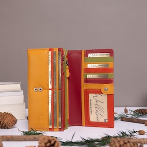 May include: A multi-colored leather wallet featuring a yellow exterior and a red interior with multiple card slots. The wallet displays the brand name Walletree and the text Genuine Leather on several gold-colored inserts and a clear ID window.