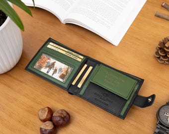 Könnte beinhalten: Offene schwarze und grüne Ledergeldbörse mit Druckknopfverschluss. Die Geldbörse hat ein Familienfoto und die Worte "I Choose You Every day Forever" aufgedruckt. Eine schwarze Uhr und Tannenzapfen liegen neben der Geldbörse.