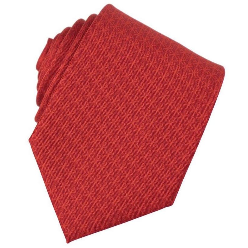 May include: A folded red tie with a repeating geometric pattern. The tie is a solid red color and appears to be made of a woven fabric. The tie is angled, showing the tip and the folded portion.