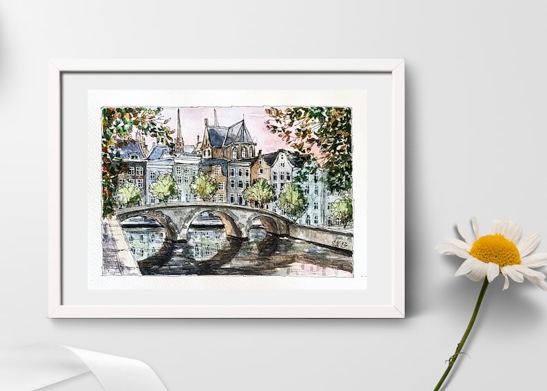 May include: Watercolor painting of a bridge over a canal in a European city. The buildings are in the background, and there are trees on either side of the bridge. The water is reflecting the sky and the buildings.