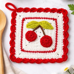 May include: A square, handmade crochet potholder with a cherry design. The potholder features a white center with a red border and a red scalloped edge. The cherry design includes two red cherries, green leaves, and a brown stem.