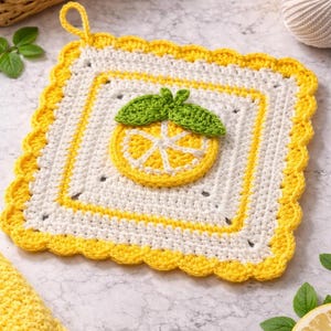 May include: A square, white and yellow crochet potholder with a lemon design. The potholder has a yellow scalloped edge and a yellow border. A crocheted lemon slice with green leaves is in the center.