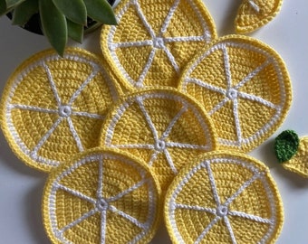 Puede incluir: Conjunto de siete posavasos de ganchillo con forma de limón en amarillo y blanco. Los posavasos están hechos con un punto texturizado y tienen un borde blanco.