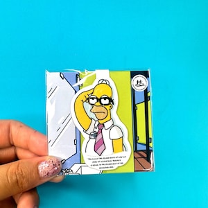 May include: A sticker of Homer Simpson from The Simpsons cartoon. Homer is wearing a white shirt, pink tie, and glasses, saluting. The sticker is on a colourful background with text. The sticker is in a clear plastic sleeve.