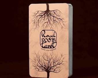May include: A deck of tarot cards with a light brown background. The cards feature a tree and root design with the words "Royal Roots Tarot Divine Lea Goddess" in a stylized font. The edges of the cards are silver.