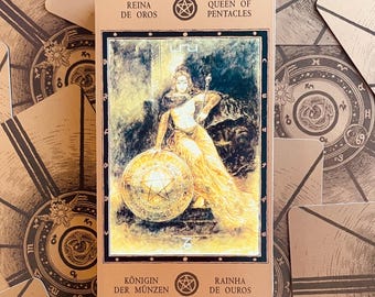 Może przedstawiać: Karta tarota z ilustracją kobiety w złotej sukni trzymającej pentakl. Karta oznaczona jest jako "Queen of Pentacles" po angielsku, z dodatkowym tekstem w języku hiszpańskim, niemieckim i portugalskim. Tło przedstawia inne karty tarota.