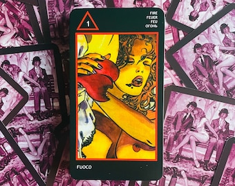 May include: Tarot card with a black background and a red triangle with the number 1 inside. The card features a woman with long red hair holding a red heart. The text on the card reads "FIRE FEUER FEU ОГОНЬ FUOCO".