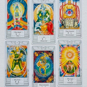 Pu&ograve; includere: Sei carte dei tarocchi con illustrazioni colorate e cornici argentate. Le carte sono del mazzo "TRUMPS" e presentano i seguenti titoli: L'Eone, L'Arte, Il Carro, Il Matto, L'Universo e Il Sole.