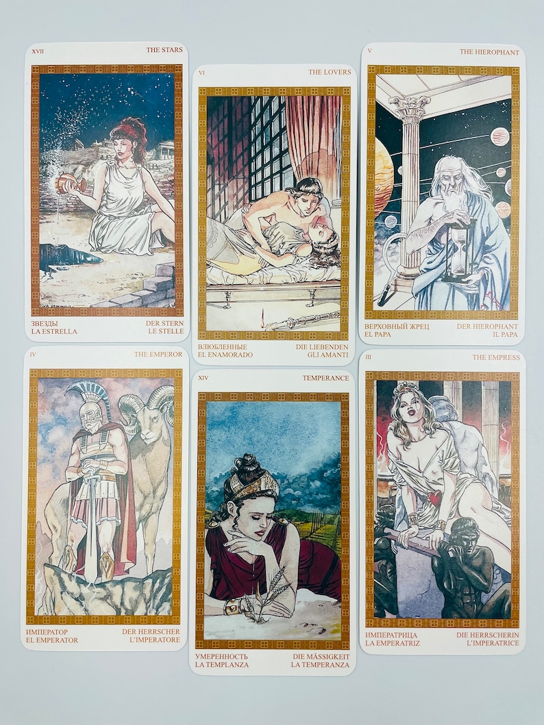May include: Tarot card deck featuring illustrations of the Major Arcana cards. The cards are in a gold frame with a white background. The cards are arranged in three rows of three cards each. The cards are numbered from I to XXI.