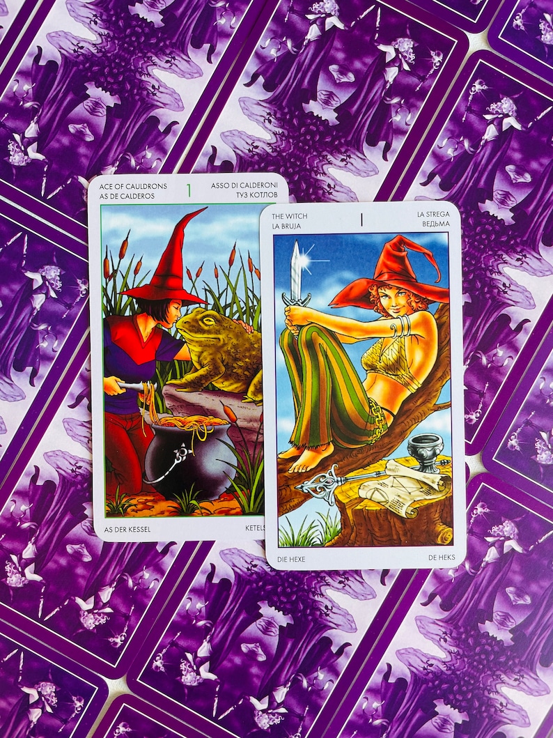 Peut inclure: Deux cartes de tarot, l'une repr&eacute;sentant une sorci&egrave;re avec une dague et l'autre une sorci&egrave;re remuant un chaudron avec une grenouille. Les cartes sont du jeu "The Witch" et pr&eacute;sentent le texte "The Witch, La Bruja, La Strega, Ведьма, Die Hexe, De Heks".