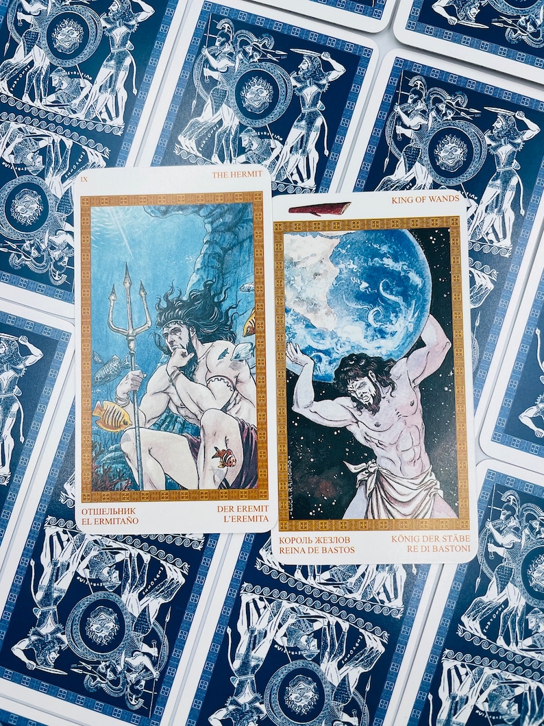 May include: Two tarot cards, The Hermit and King of Wands, with blue and gold borders. The Hermit card depicts a man with a trident standing in the ocean. The King of Wands card depicts a man holding a globe.