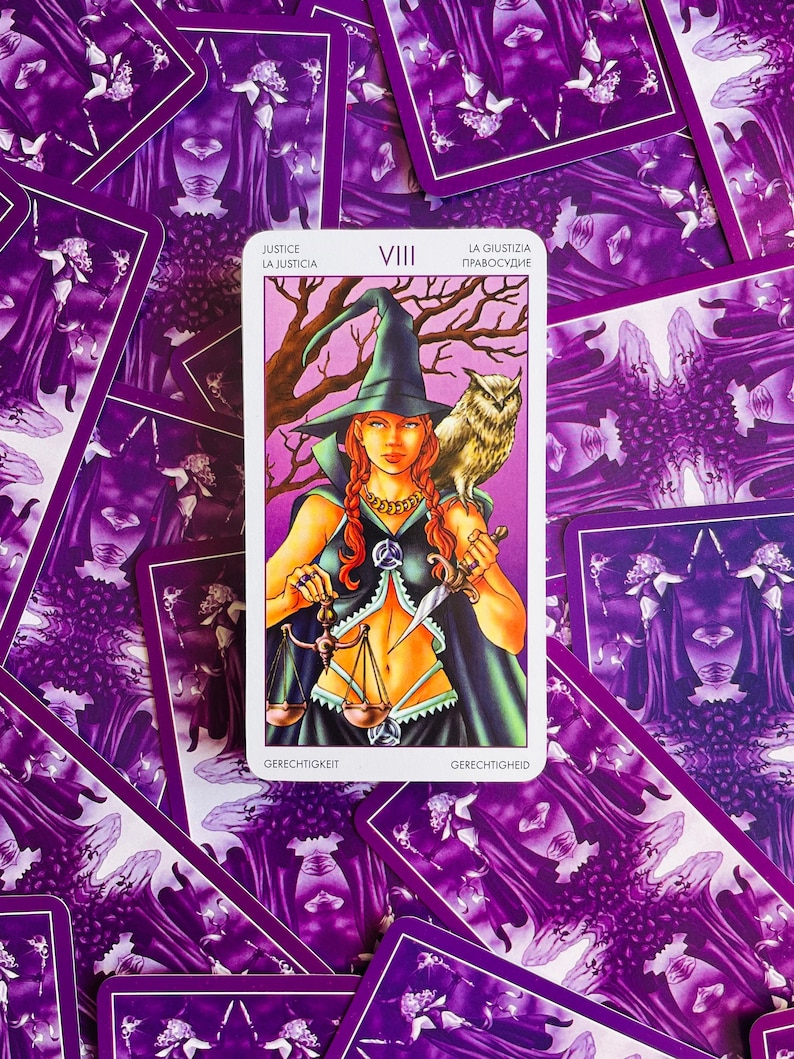 Peut inclure: Carte de tarot repr&eacute;sentant la Justice, la huiti&egrave;me carte des Arcanes Majeurs. La carte repr&eacute;sente une femme portant un chapeau et une robe verts, tenant une &eacute;p&eacute;e et une balance. La carte est entour&eacute;e d'autres cartes de tarot.
