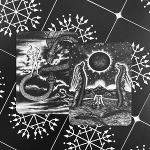 Może przedstawiać: Dwie czarno-białe karty tarota. Karta po lewej to karta VII, Rydwan, i przedstawia postać stojącą na rydwanie ciągniętym przez dwa smoki. Karta po prawej to karta XVIII, Księżyc, i przedstawia dwie postacie stojące w zbiorniku wodnym z pełnią księżyca na niebie.