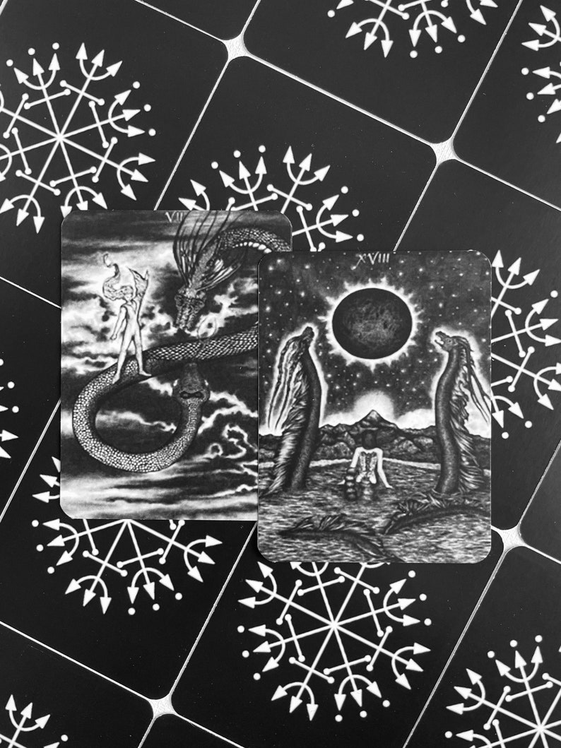 Może przedstawiać: Dwie czarno-białe karty tarota. Karta po lewej to karta VII, Rydwan, i przedstawia postać stojącą na rydwanie ciągniętym przez dwa smoki. Karta po prawej to karta XVIII, Księżyc, i przedstawia dwie postacie stojące w zbiorniku wodnym z pełnią księżyca na niebie.