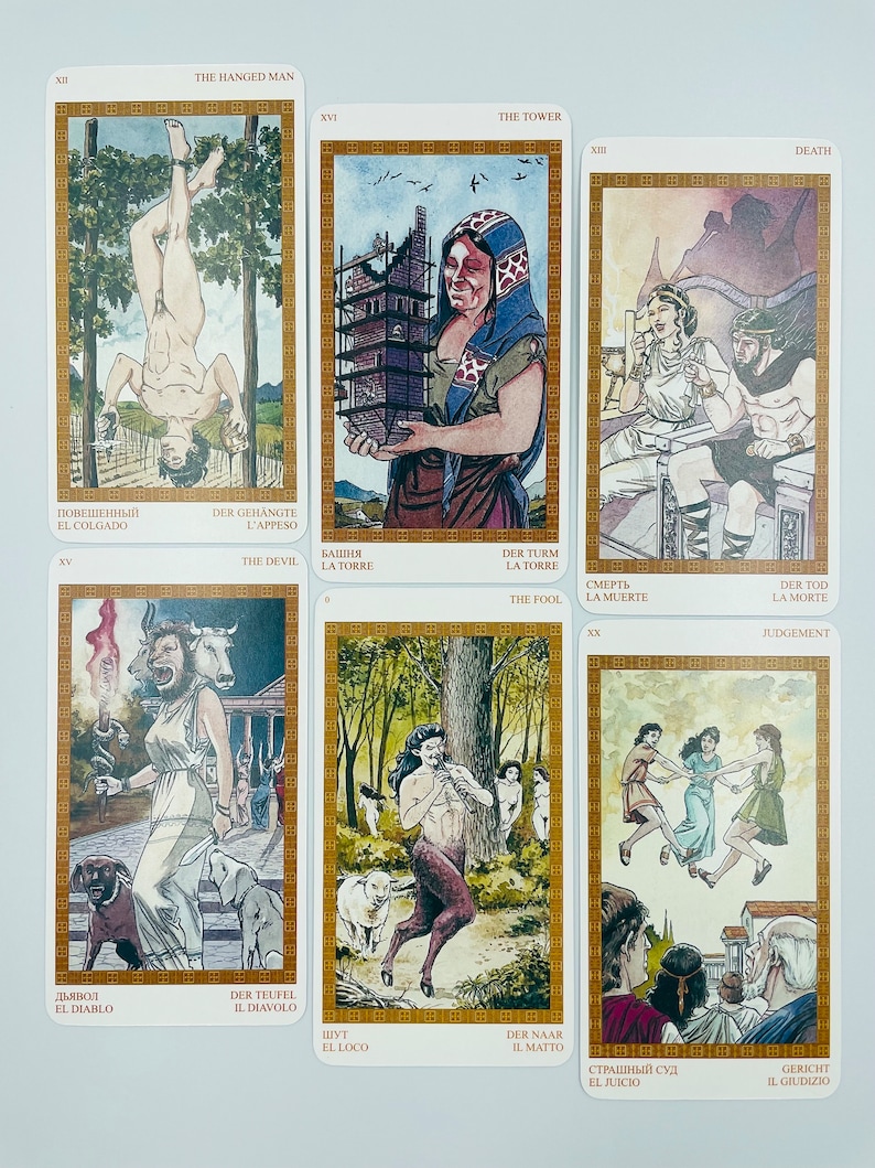 May include: A set of tarot cards with colorful illustrations depicting scenes from the major arcana. The cards are arranged in a grid with the card names and numbers visible. The cards are in a gold frame with a white background.