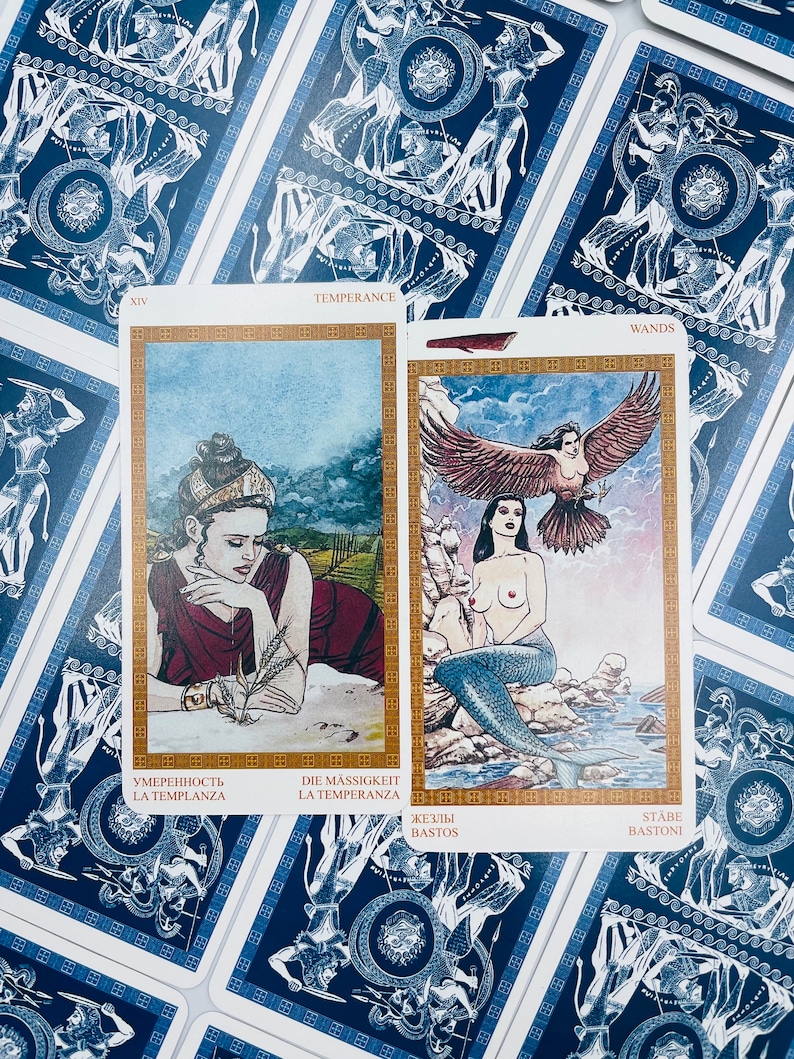 May include: Two tarot cards, one with a woman pouring water from a golden pitcher into a cup, and the other with a mermaid with a bird on her head. The first card is labeled "Temperance" and the second card is labeled "Wands".