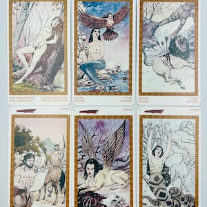 May include: A set of ten tarot cards from the Wands suit. The cards feature illustrations of a queen, a mermaid, a lion, a man with a scroll, a woman with wings, and a woman with snakes. The cards are in a white border with gold accents.