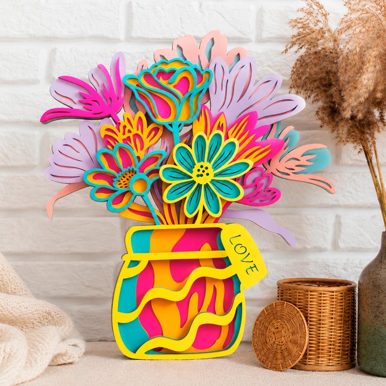 May include: A multi-layered wooden wall art piece featuring a bouquet of stylized flowers in vibrant shades of hot pink, turquoise, yellow, and lavender. The flowers are arranged in a colorful jar with a yellow tag that has the word LOVE printed on it.