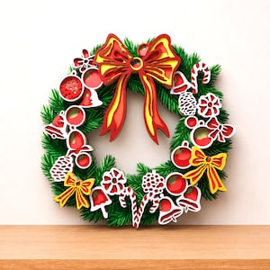 May include: A Christmas wreath featuring green artificial pine needles decorated with layered wooden ornaments. The ornaments include red and yellow bows, red spheres, white bells, candy canes, and pinecones arranged around the circular frame.