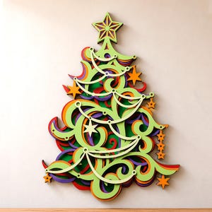 Puede incluir: Una decoración de pared multicapa con forma de árbol de Navidad, que presenta intrincados recortes en espiral en tonos vibrantes de verde lima, naranja, morado y rojo. El diseño está rematado con una estrella y acentuado con estrellas colgantes.