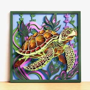 May include: A square, multi-layered wall art piece featuring a sea turtle swimming among aquatic plants. The turtle has a brown and tan shell with green accents. The background consists of light blue, pink, and green layered cutouts.