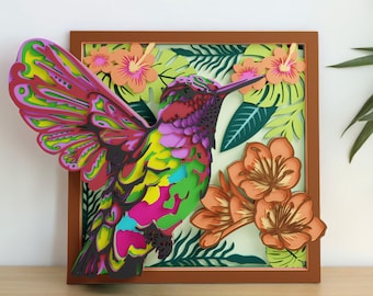 May include: A multi-layered paper art piece in a brown frame featuring a vibrant hummingbird with pink, yellow, and green wings. The bird is surrounded by orange hibiscus flowers and green tropical leaves, creating a dimensional effect.