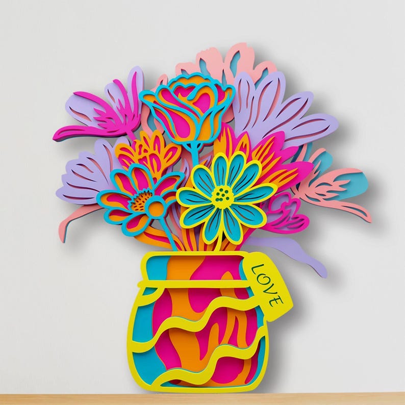 May include: A multi-layered wooden wall art piece featuring a vibrant bouquet of flowers in shades of pink, purple, orange, and blue. The flowers are arranged in a stylized vase with a yellow tag attached that has the word LOVE printed on it.