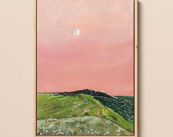 May include: A painting of a green hill with a pink sky and a white moon. The hill is covered in green grass and white flowers. The sky is a soft pink color with a white moon in the upper center of the painting.