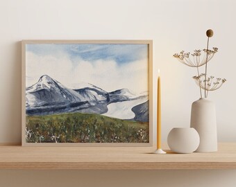 Pode incluir: Uma pintura a aquarela emoldurada de uma cordilheira com picos cobertos de neve e um vale com um rio. A pintura está em uma moldura de madeira clara e está pendurada em uma parede branca.