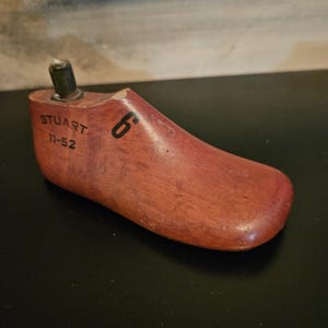 May include: A wooden shoe last with the text "STUART 11-52" and the number "6" printed on it.
