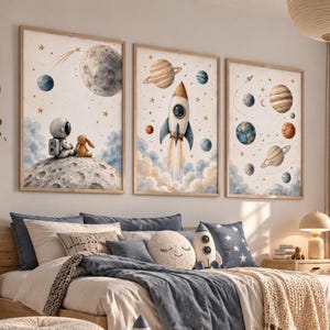 Peut inclure: Trois cadres muraux illustrant des thèmes spatiaux. L'affiche de gauche montre un astronaute et un lapin sur la lune. Celle du centre représente une fusée décollant à travers des nuages. L'affiche de droite présente diverses planètes et étoiles.