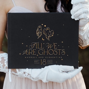 May include: Black book with gold lettering and illustrations. The cover reads "Till We Are Ghosts" with ghost and star illustrations. The book also includes the names "Maxwell and Clementine" and the date "Oct. 18 2021".
