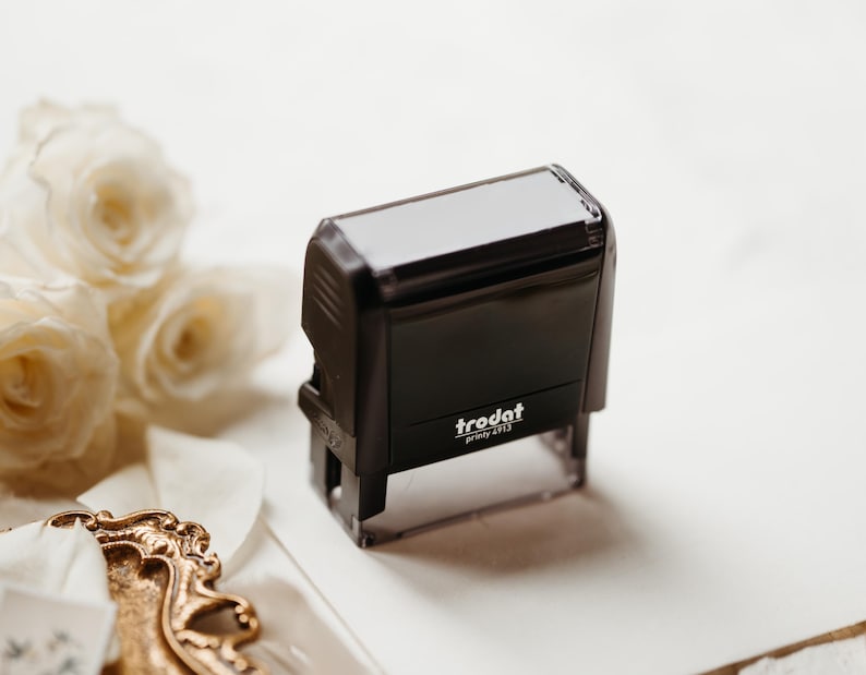 May include: A black self-inking stamp with a clear plastic base. The stamp has the text "trodat printy 4613" printed on it.